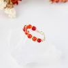 A ring adorned with natural rose quartz, placed on a piece of white quartz, itself placed on a white sheet.