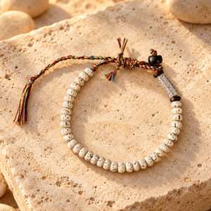 Handgewebtes tibetisches Armband, präsentiert auf warmem Naturstein